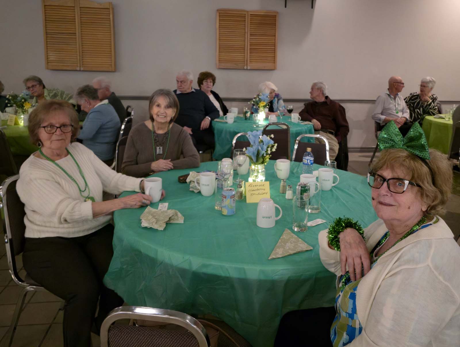 membres d'Amicale assis aux tables décorées pour la Saint-Patrick