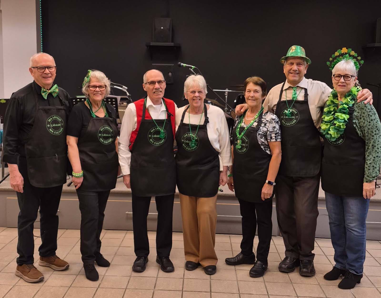 membres et bénévoles en tablier devant la scène