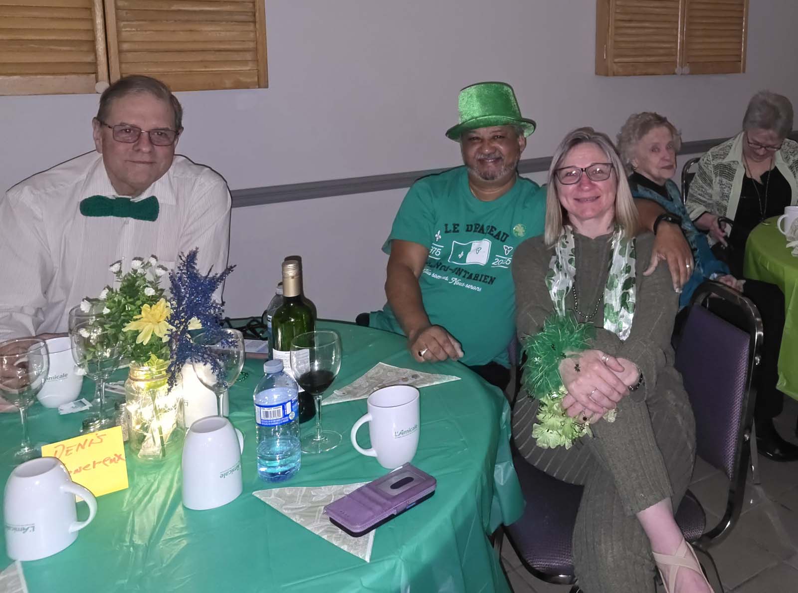membres d'Amicale assis aux tables décorées pour la Saint-Patrick