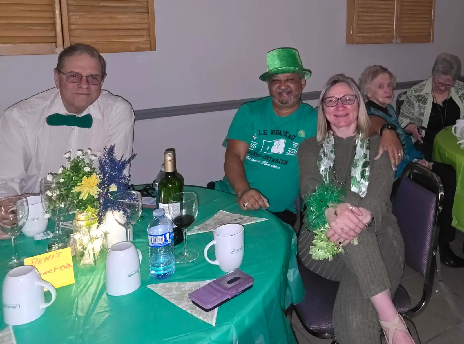 membres d'Amicale assis aux tables décorées pour la Saint-Patrick