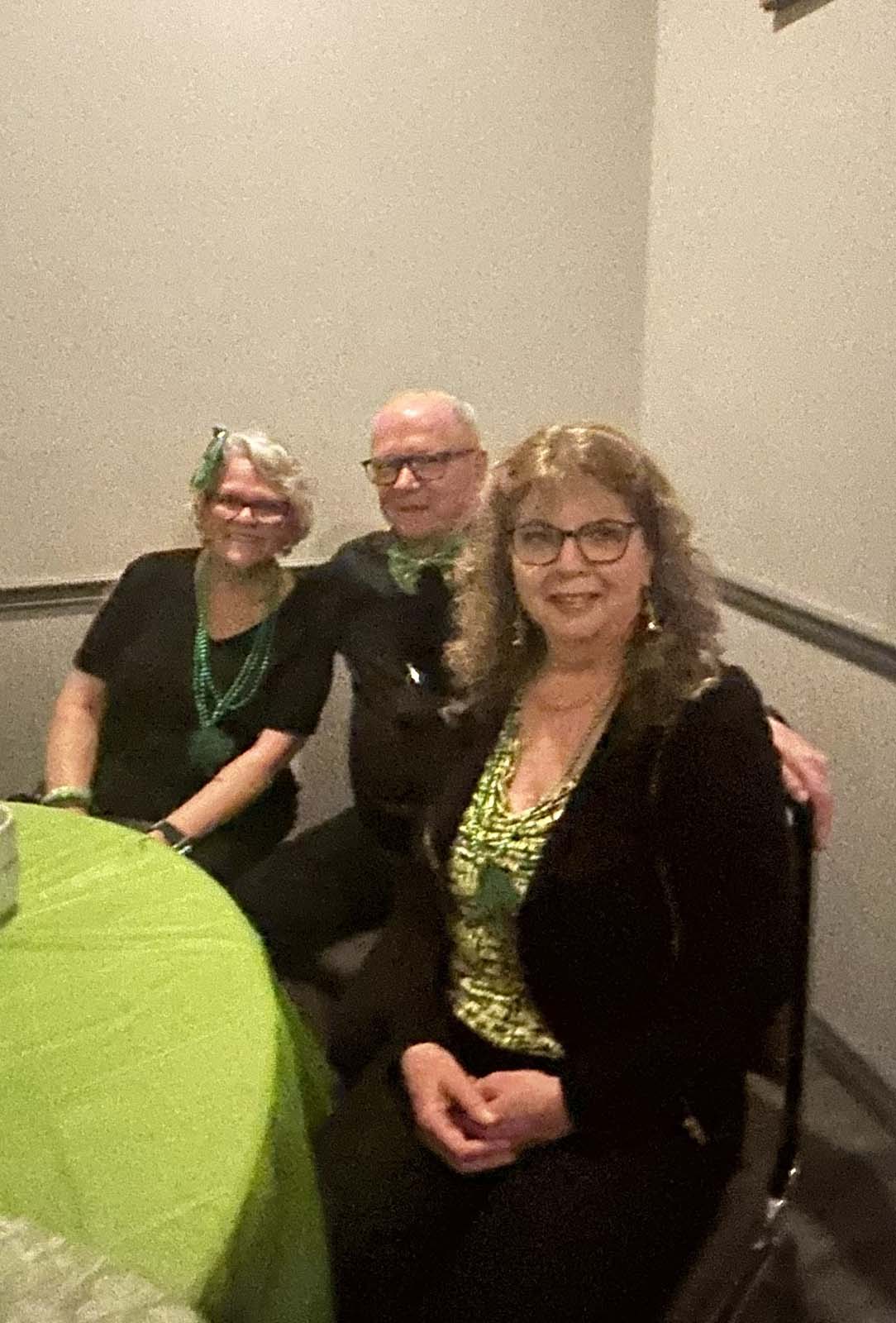 Les membres, assis aux tables décorées pour la Saint-Patrick, regardent le concert.