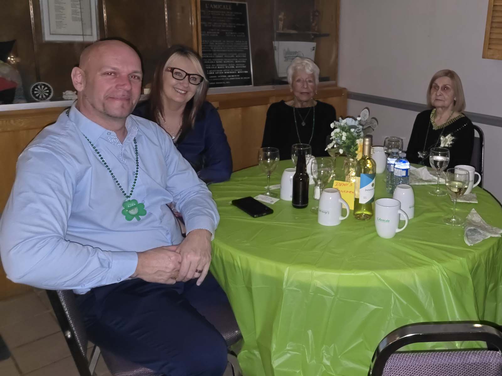 membres d'Amicale assis aux tables décorées pour la Saint-Patrick