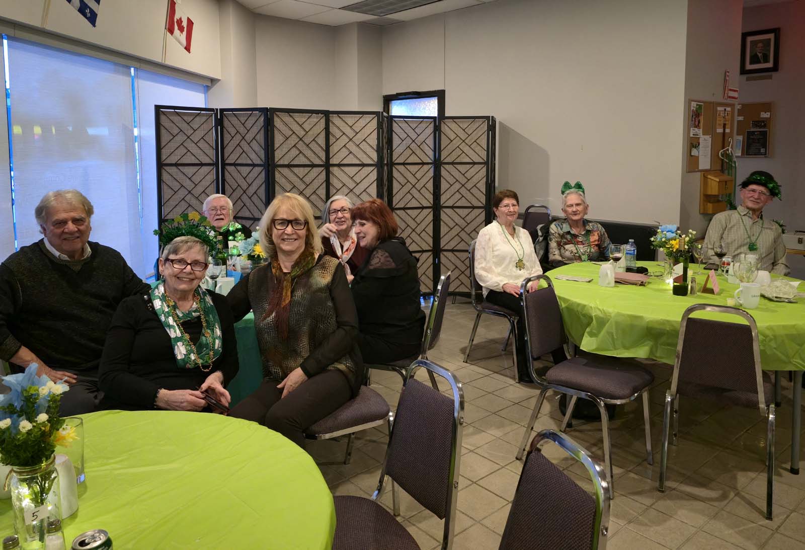 membres d'Amicale assis aux tables décorées pour la Saint-Patrick