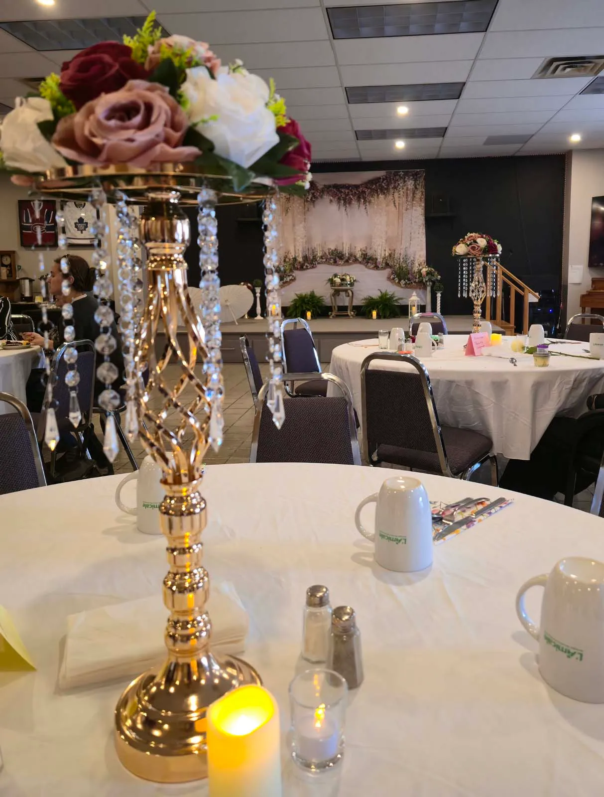 Centre de table décoré avec fleurs et chandelle lors du brunch de la Fête des Mères de l’Amicale.