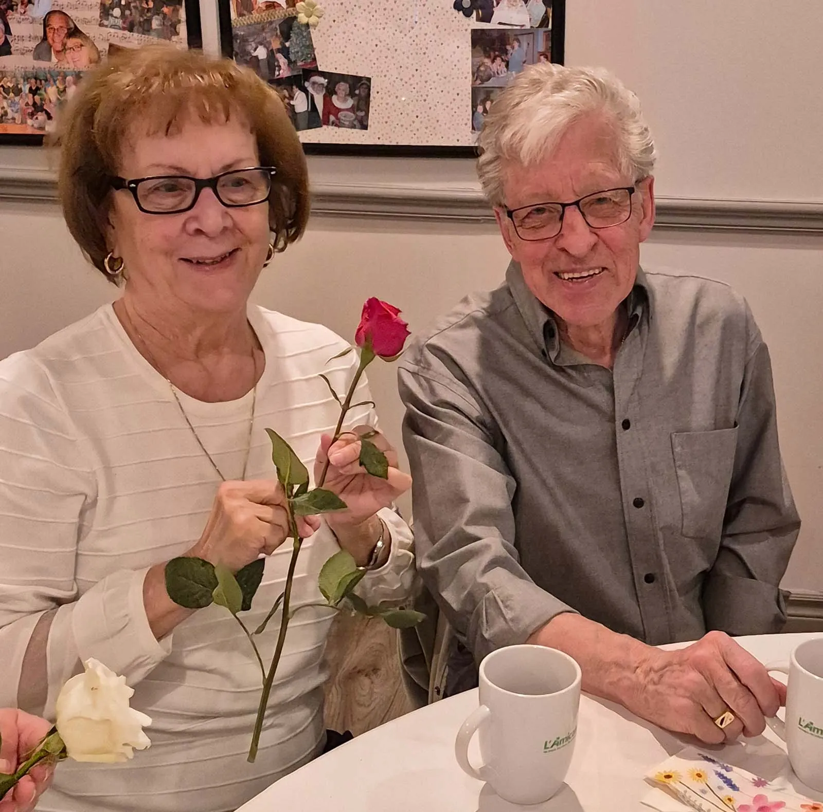 Deux participants assis à une table avec des roses pendant le brunch de la Fête des Mères de l’Amicale.