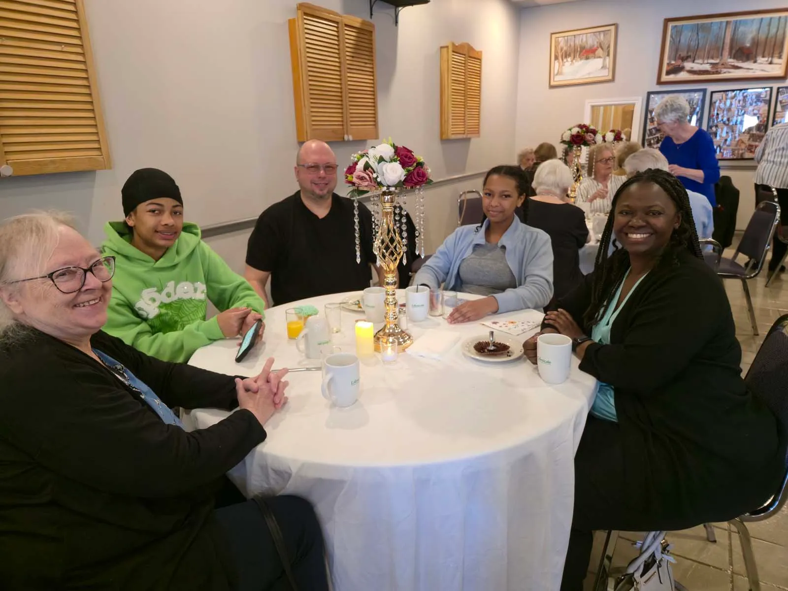 Participants réunis autour d’une table décorée pendant le brunch de la Fête des Mères de l’Amicale.