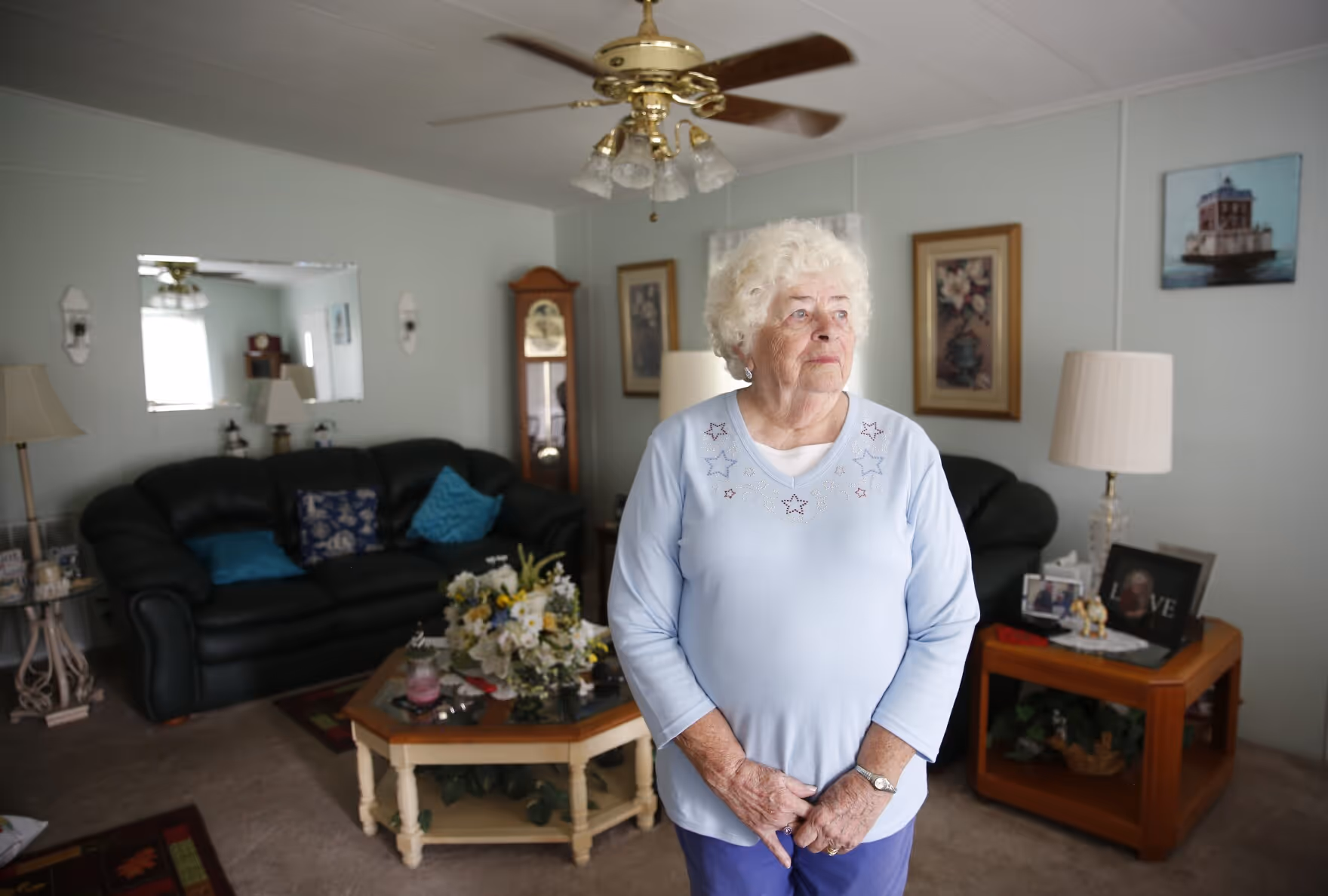 An older woman stands in her living room in Haines City, Florida. 