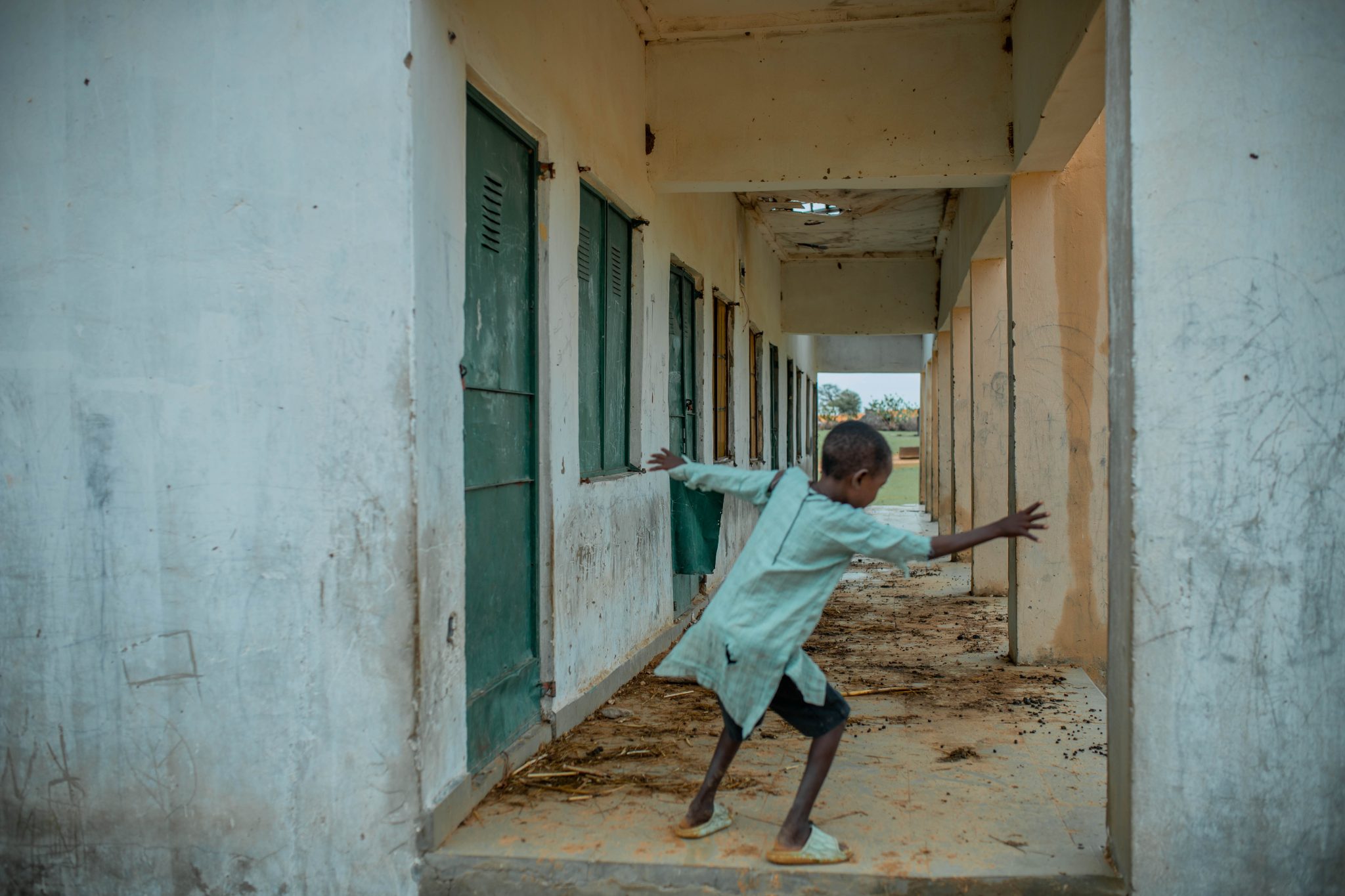 A young boy reaches across a doorway.