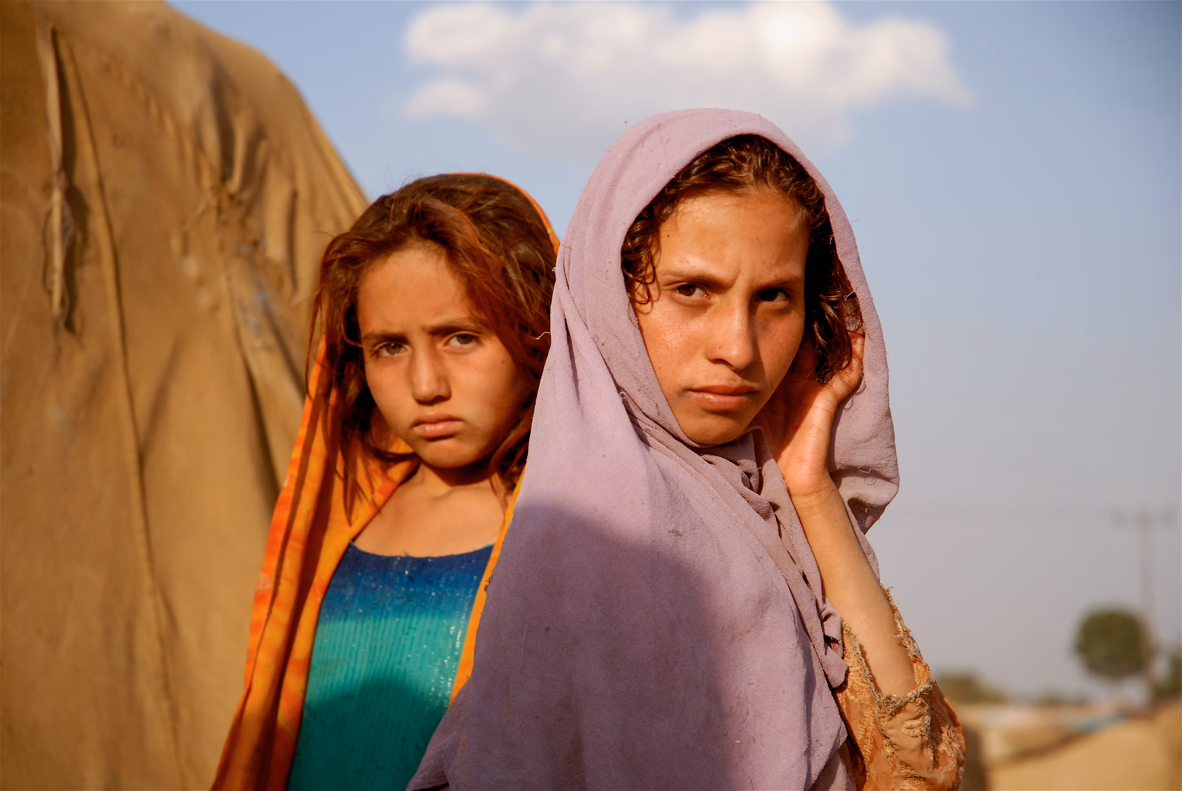 Two young girls face the camera looking suspicious
