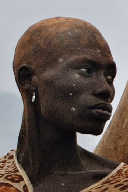 a person with close cropped hair looks to the right
