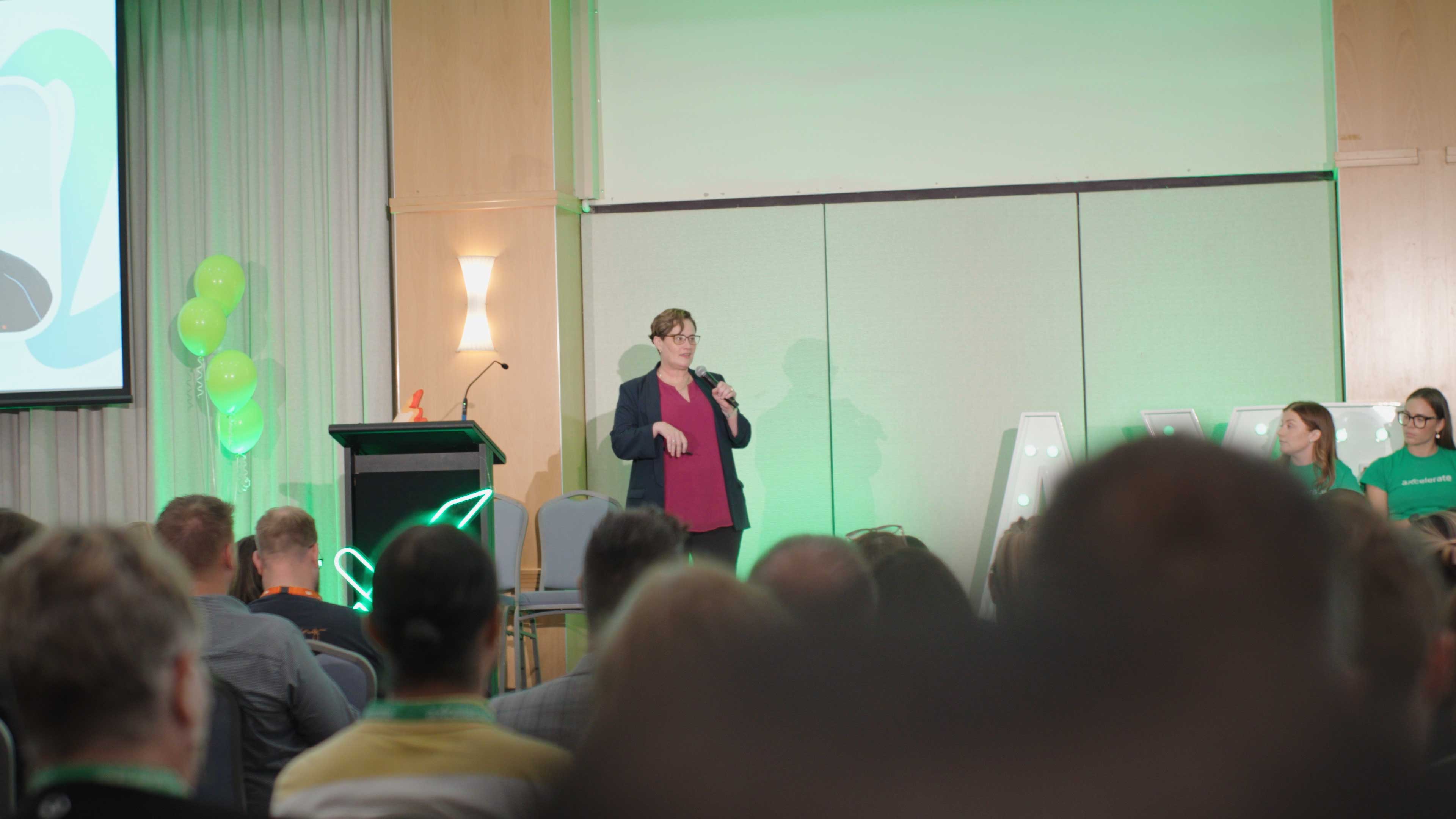 Kerri Buttery speaking on stage about AI at aXcelerate Day 2025