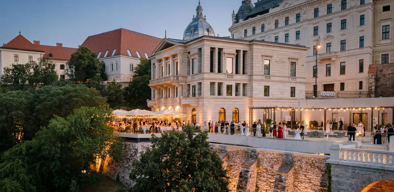 An evening reception on the illuminated terrace of the Aranybástya in Buda Castle, featuring string lights and buffet tables