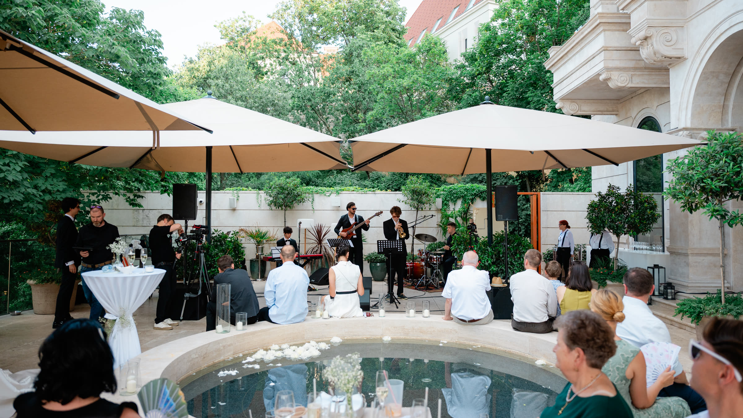 A wedding reception with live music in the garden of Aranybástya , around the fountain