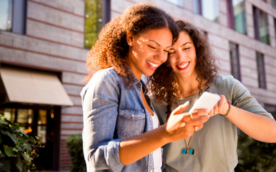 Two women looking at their phone at online ads