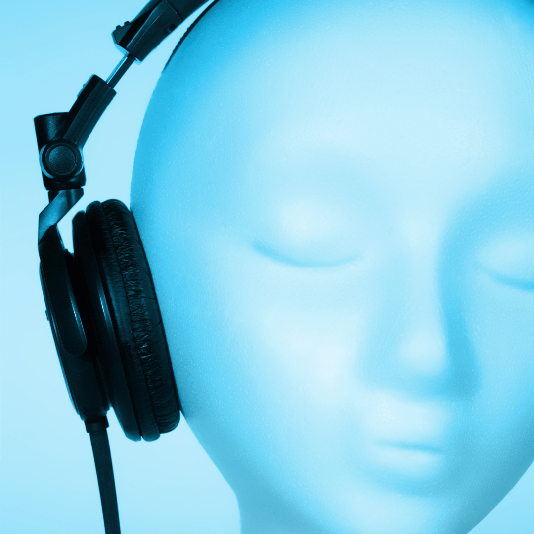 Close-up of a white mannequin head wearing black over-ear headphones against a blue background