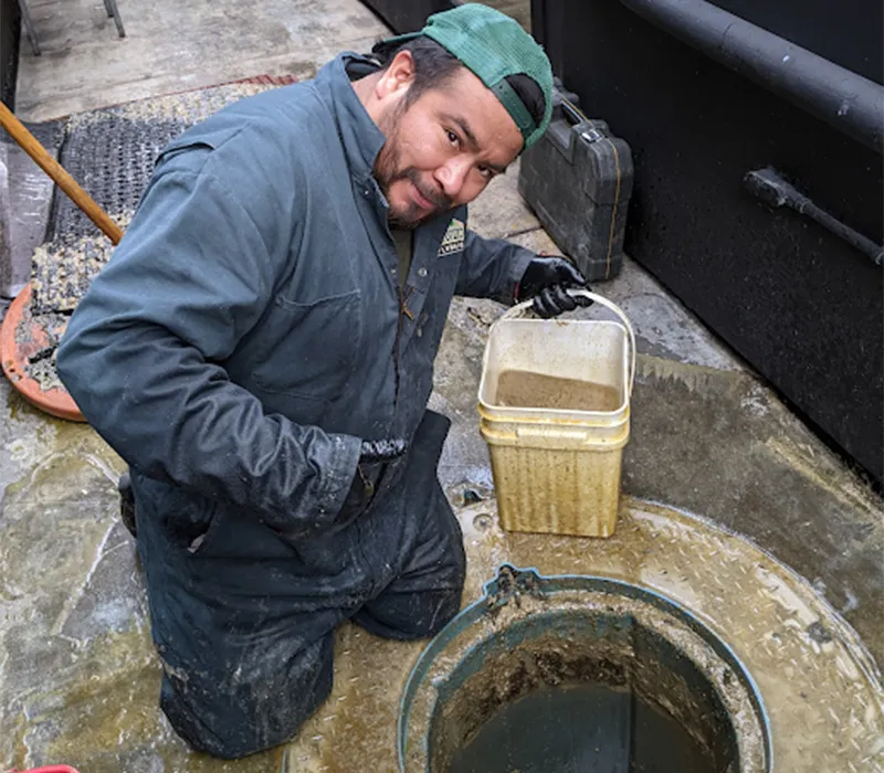 Licensed plumber performing trenchless sewer line replacement in Santa Monica yard with specialized equipment.