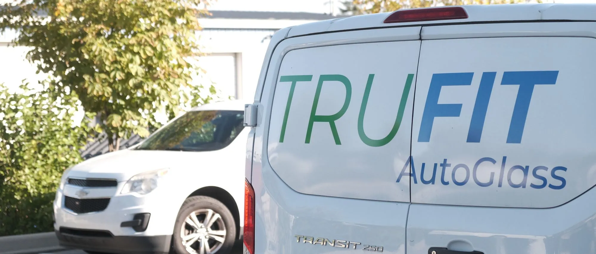 TruFit AutoGlass logo on the back of a van used for mobile auto glass services