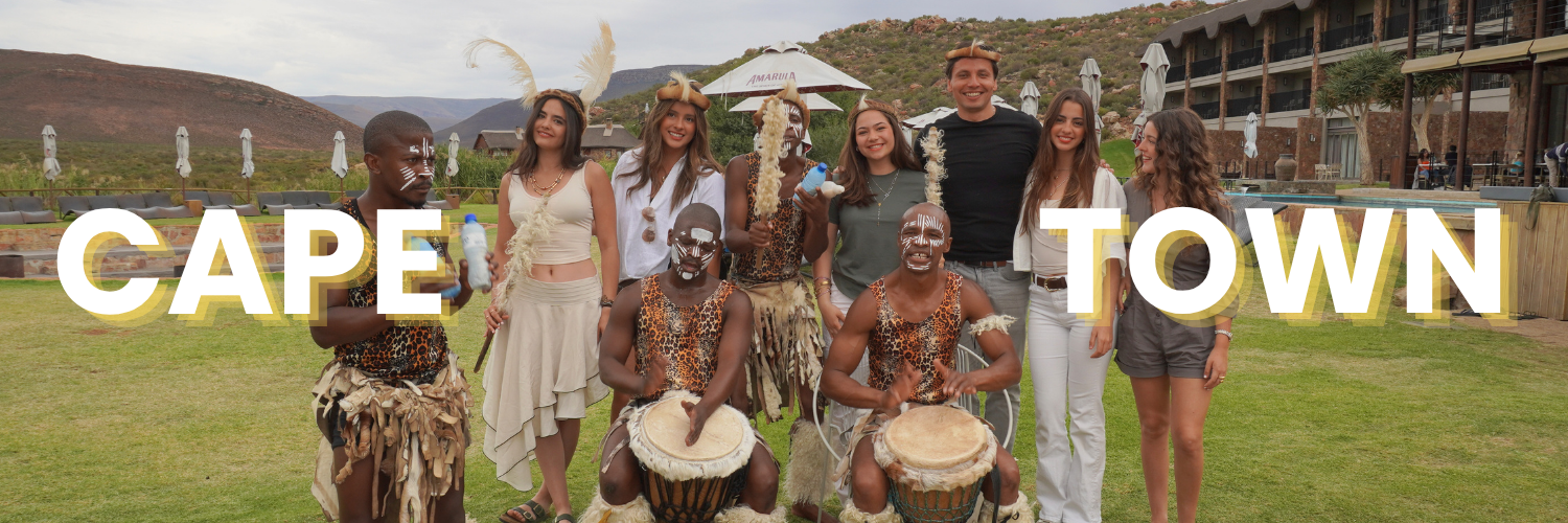 Fotografía de estudiantes de Prepa Anáhuac durante una experiencia internacional en Cape Town, Sudáfrica, participando en una actividad de intercambio cultural con una comunidad local como parte de su formación global.