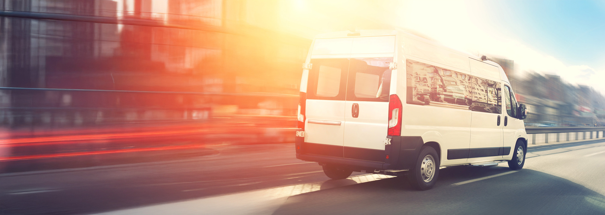 Paratransit van driving down a road.