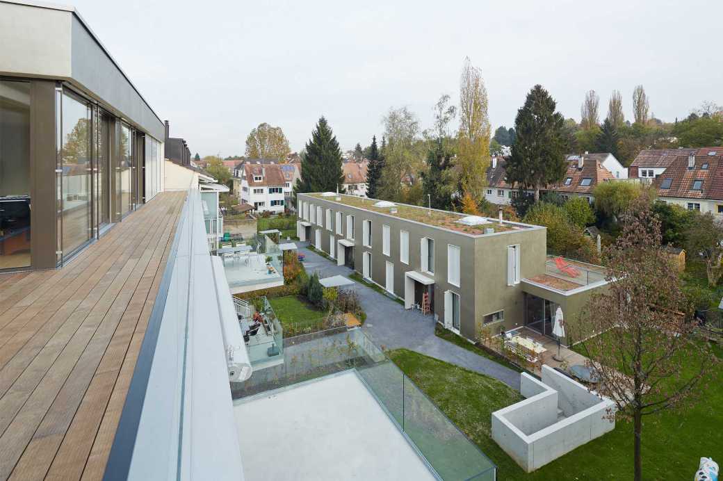 Wohnüberbauung an der Grenze zu Allschwil mit Wohnhaus entlang der Strasse und im Innenhof liegenden Atriumhäusern.