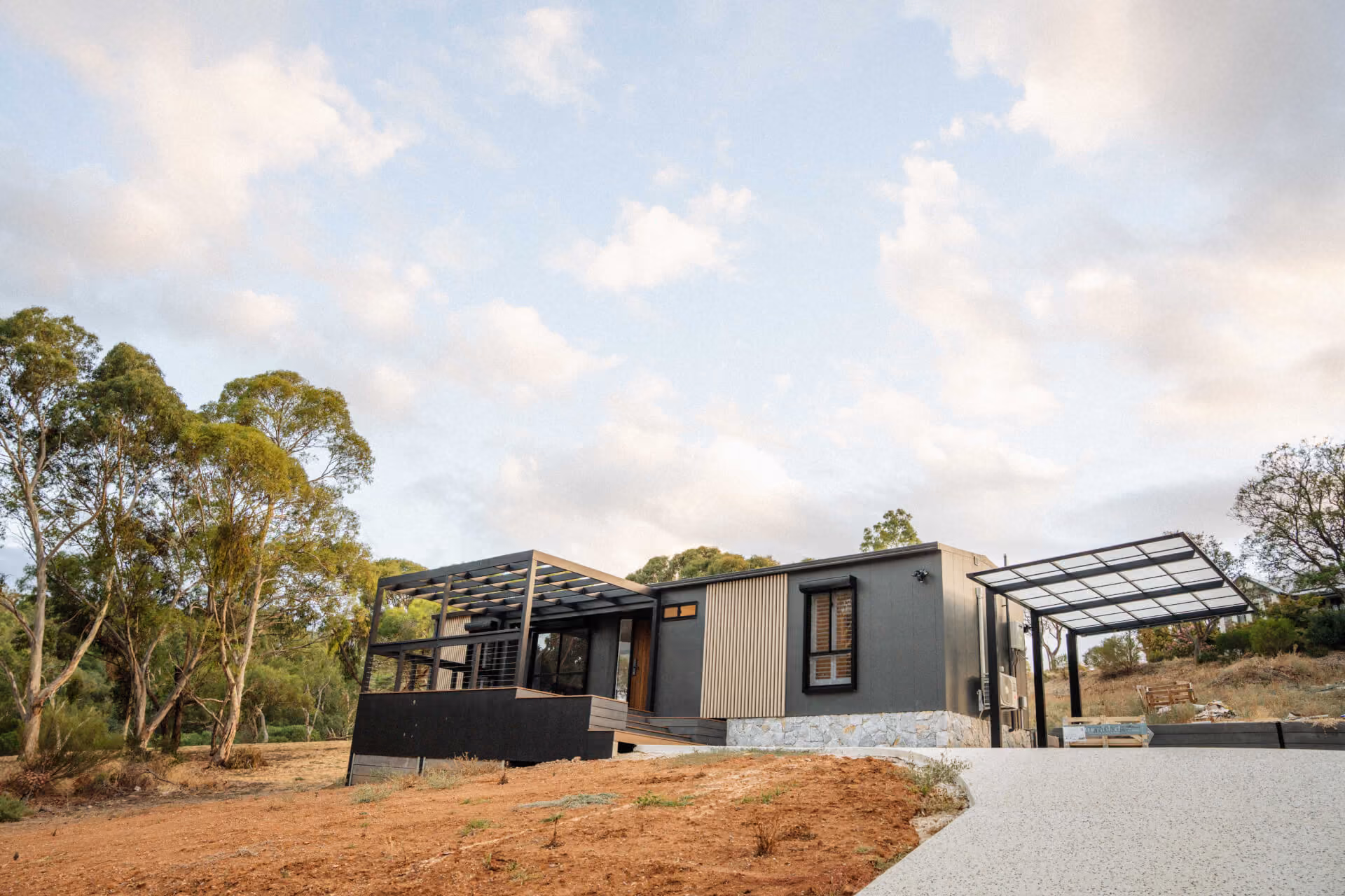 Wide exterior view of a Modify home in Paradise, Adelaide, showing the full facade, pergola structure, and surrounding trees and landscaping.