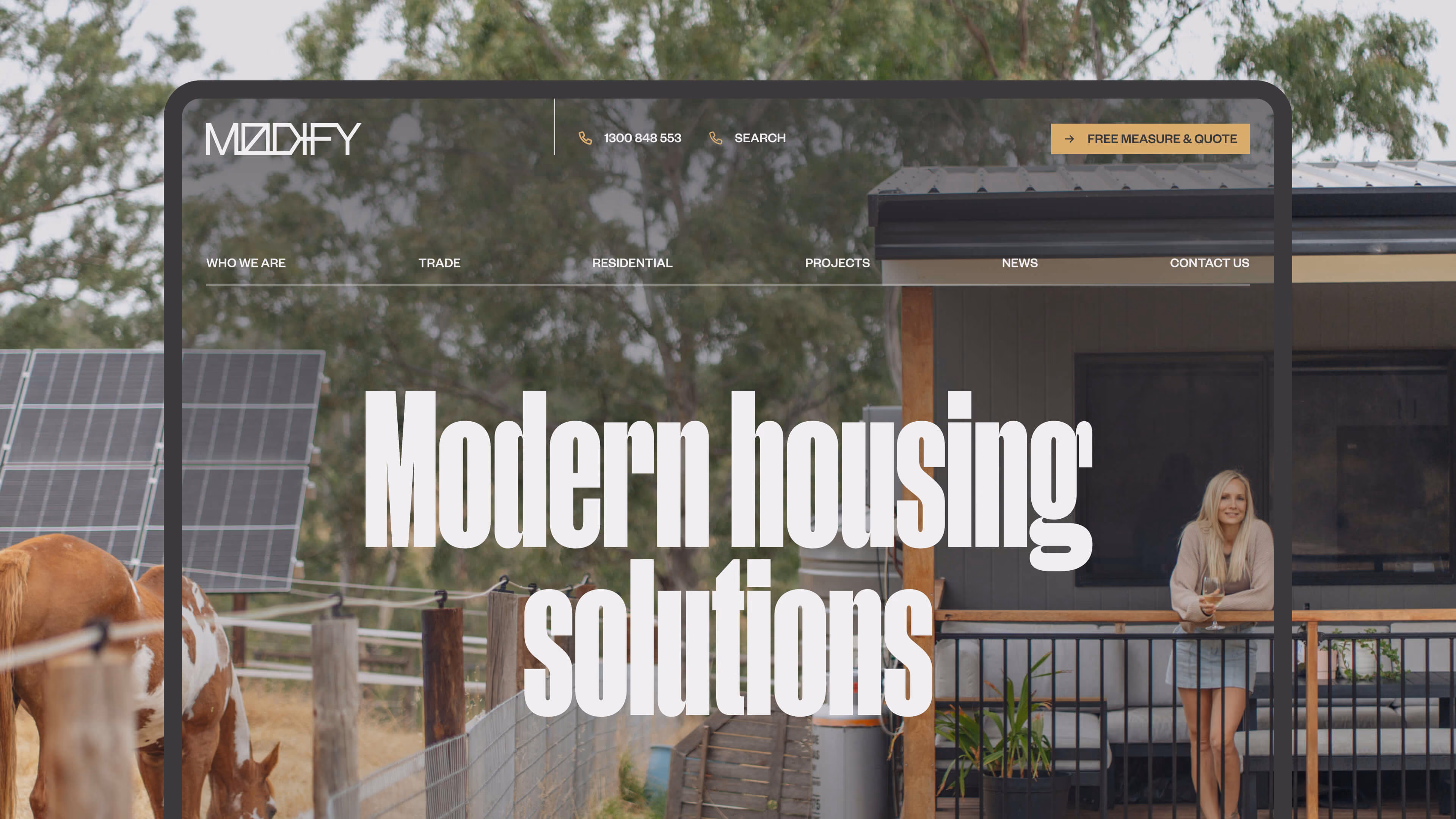 Modify Modular website hero banner reading "Modern housing solutions," with a photo of a woman on a home's veranda overlooking a paddock with horses.