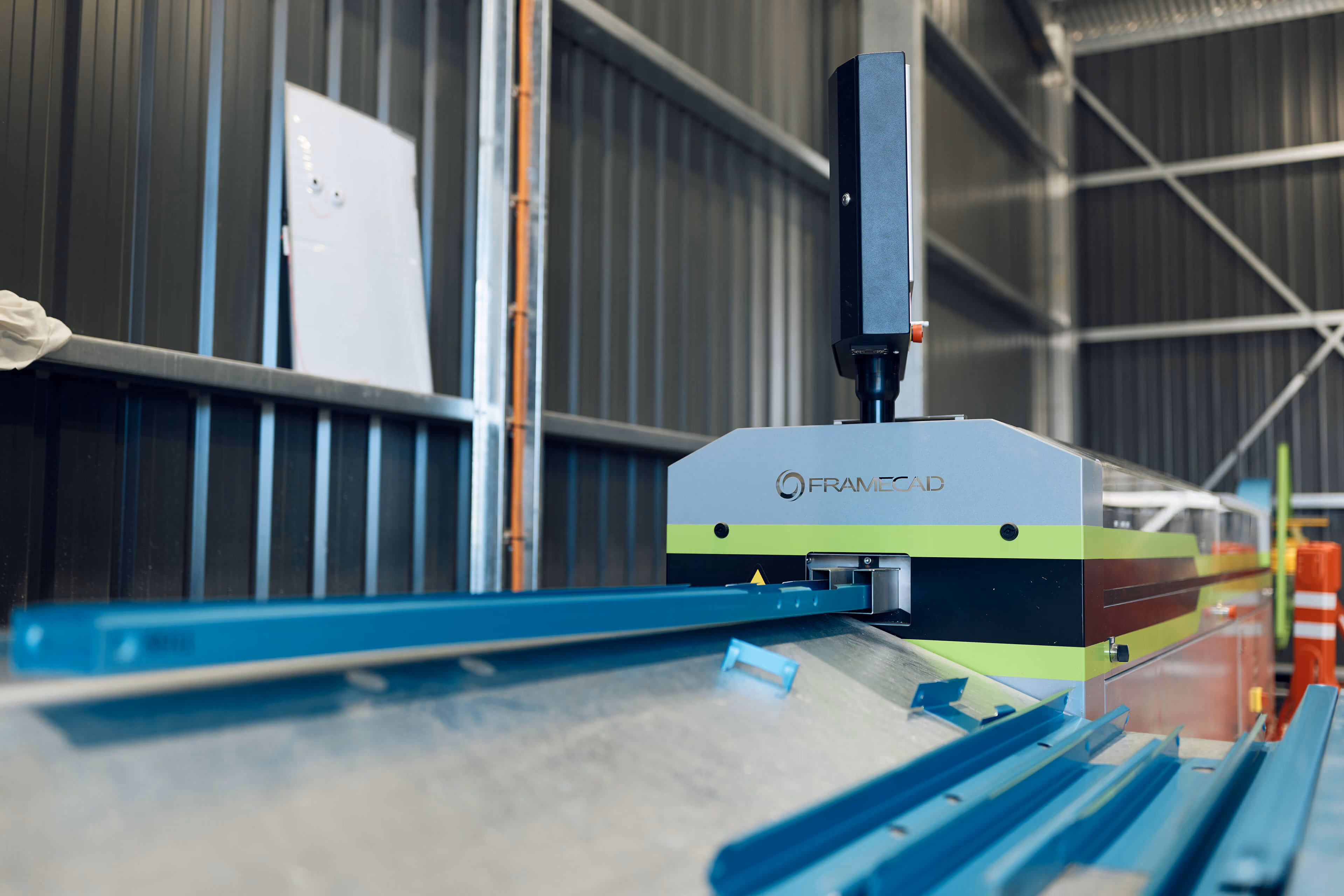 FrameCAD machine forming blue steel framing inside the Modify Steel workshop. 