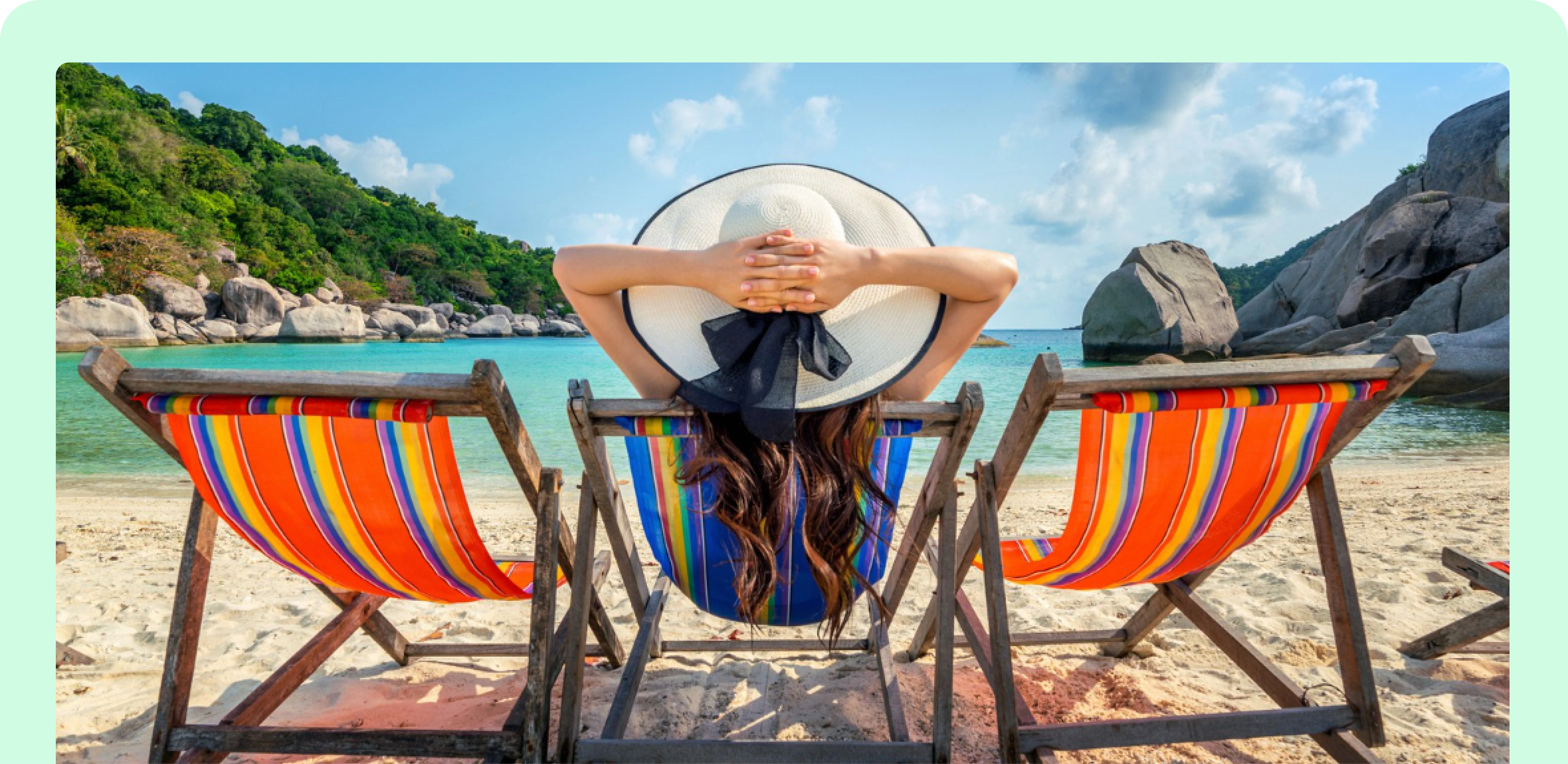 Traveler in a sun hat relaxing in a beach chair overlooking a tropical bay
