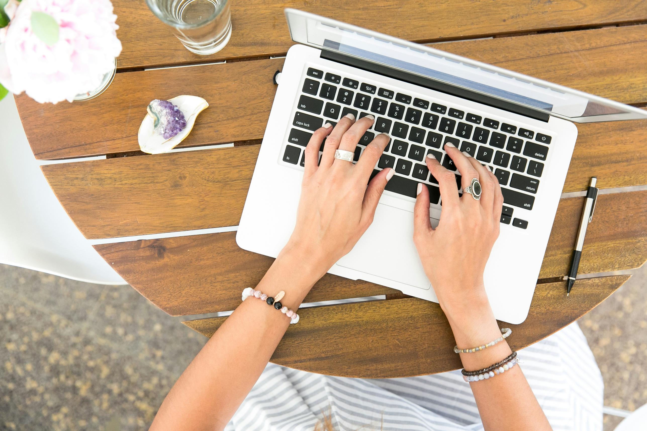 woman's hands typing on laptop
