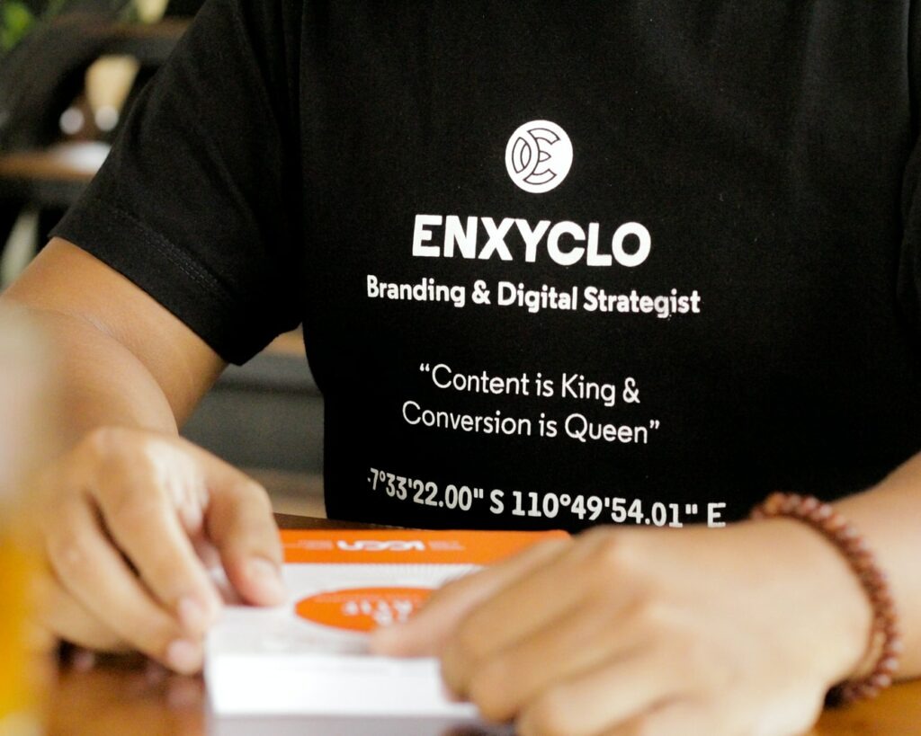 person in tee shirt that says ENXYCLO Branding & Digital Strategist - "Content is King & Conversion is Queen"