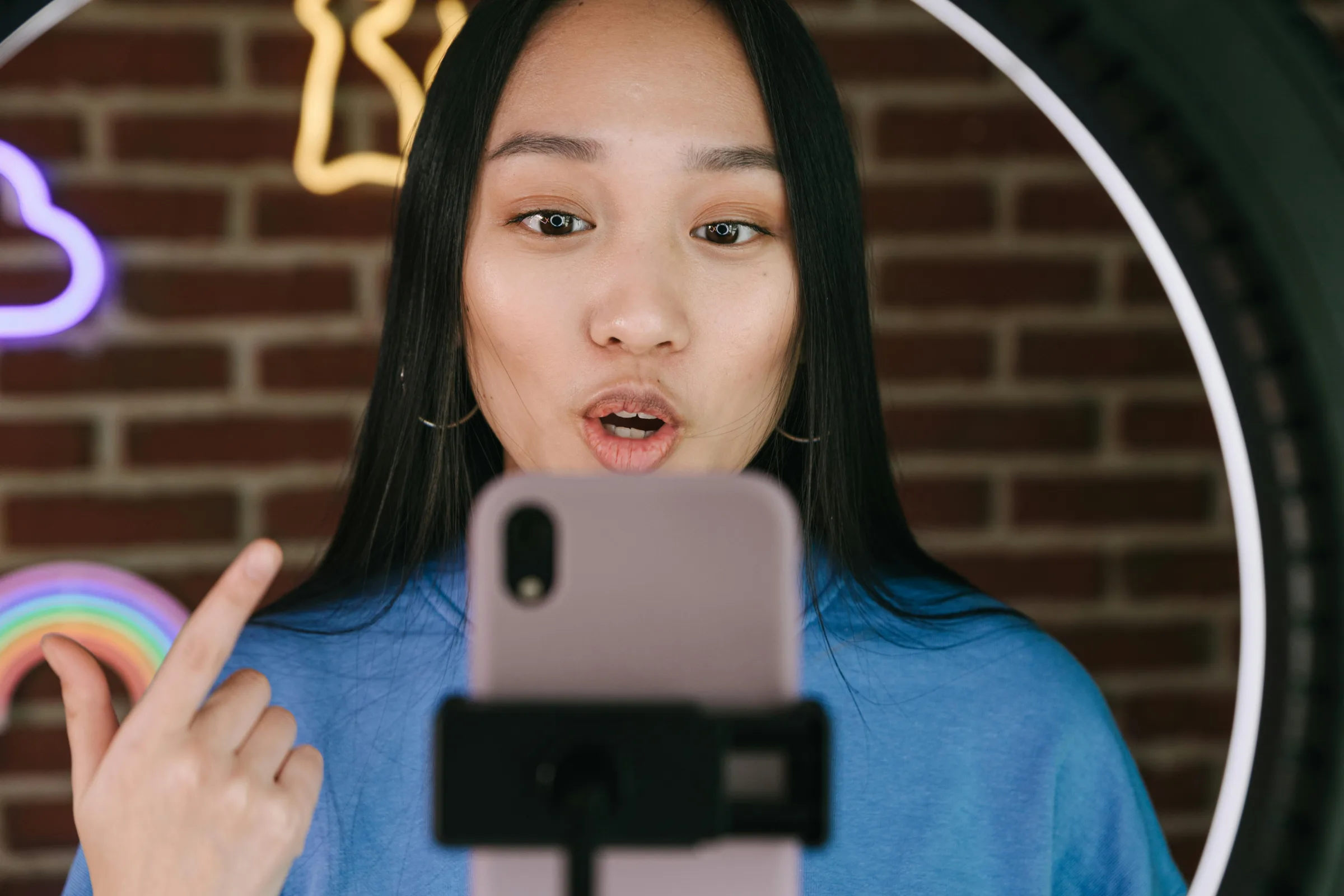 Influencer filming a video on her phone with a ring light