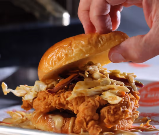 chicken sandwich with wing sauce and coleslaw