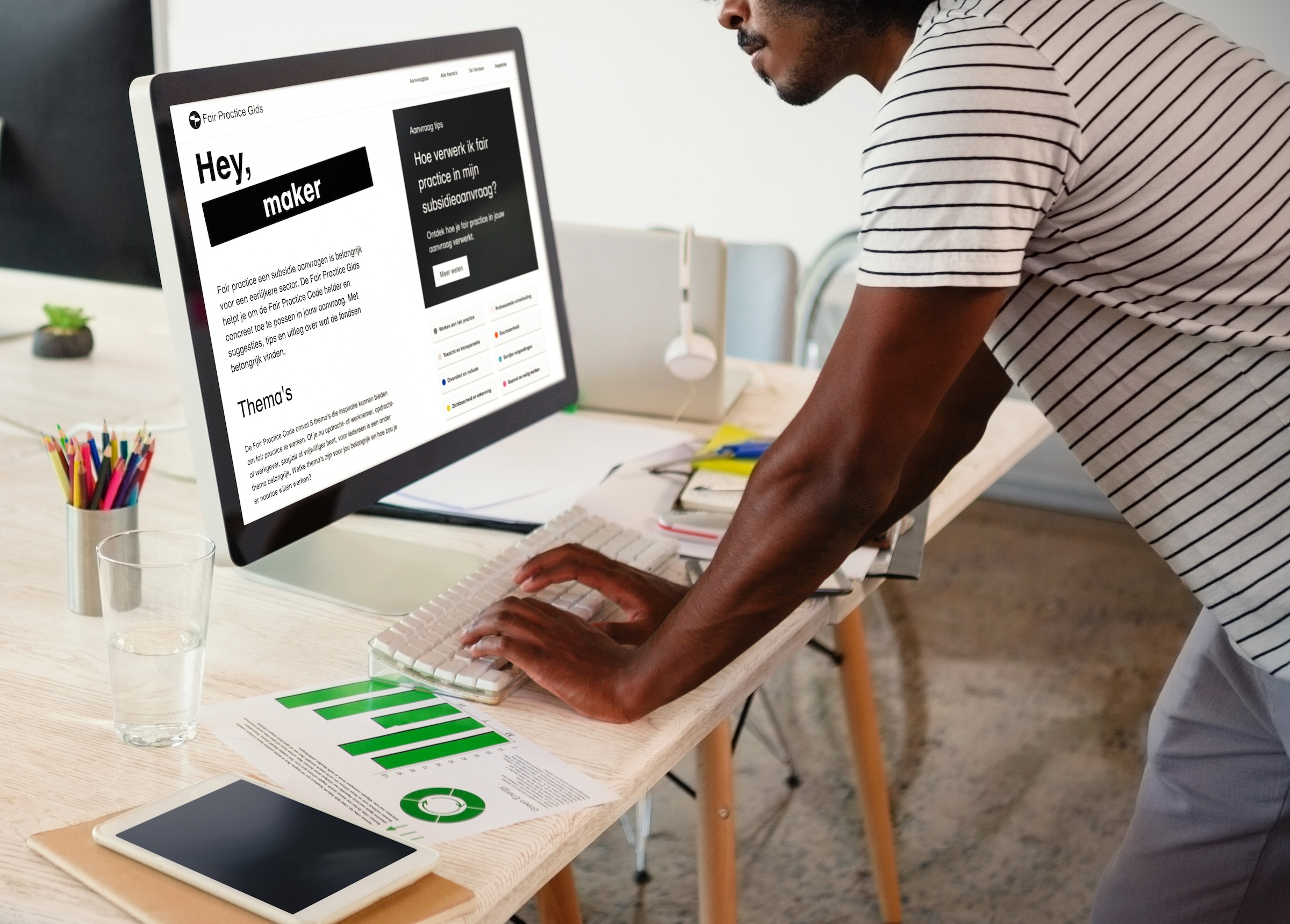 A man stands at his computer and has the Fair Practice Guide website open.