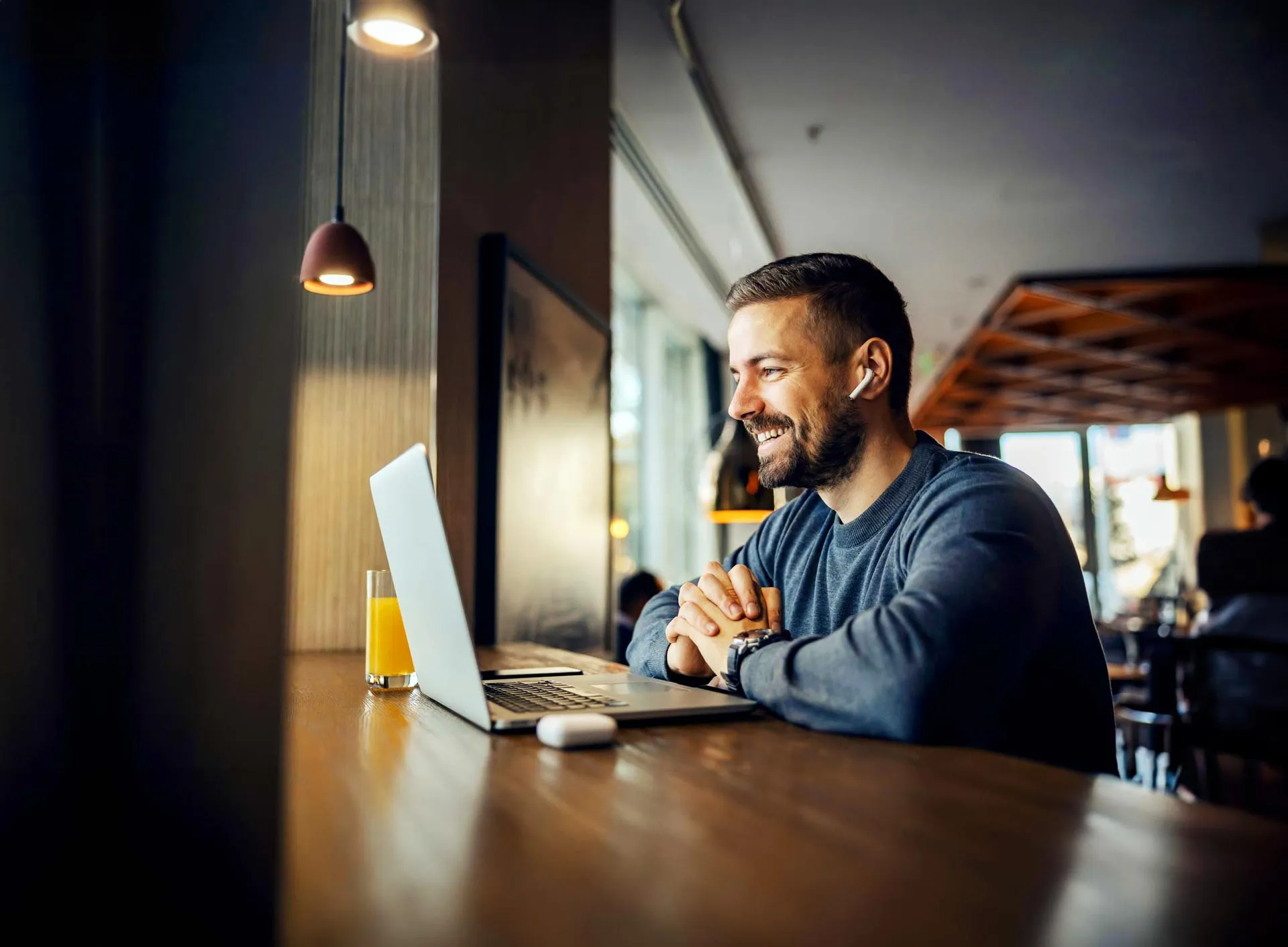 Young man types on his laptop in a warmly lit room