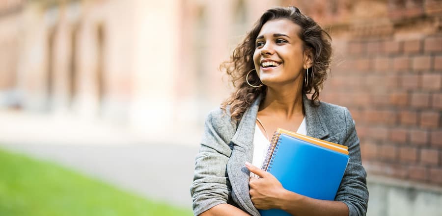 Young woman walking on college campus, feeling confident about her financial choices.