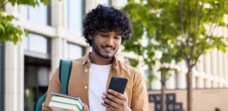 Student making a loan payment on his phone.