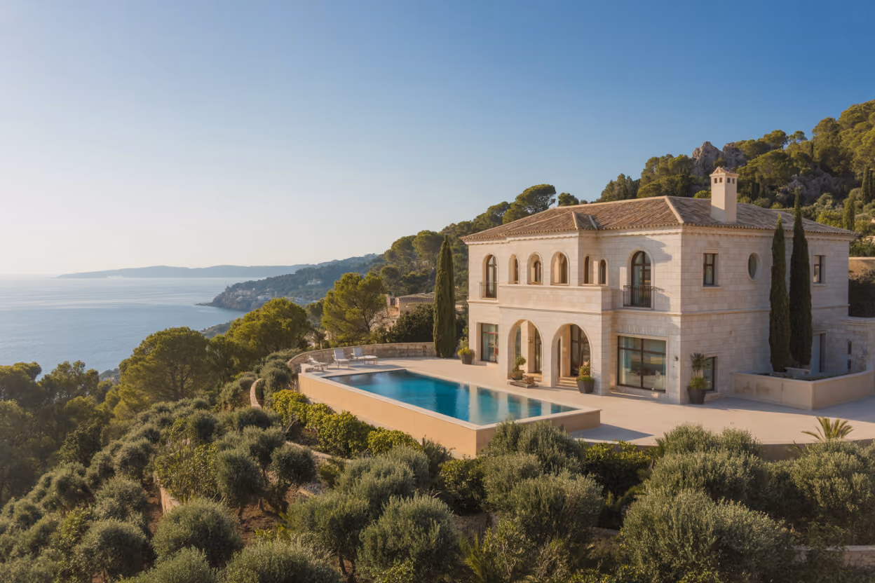 Create a realistic image of a stunning luxury villa in Mallorca with Mediterranean architecture featuring white stone walls, terracotta roof tiles, and elegant arched windows, positioned on a hillside overlooking the crystal-clear turquoise waters of the Mediterranean Sea, surrounded by lush green pine trees and manicured gardens with olive trees, captured during golden hour with warm sunlight casting gentle shadows across the property, creating an atmosphere of exclusivity and peaceful luxury living, with the distant Balearic coastline visible in the background under a clear blue sky, absolutely NO text should be in the scene.