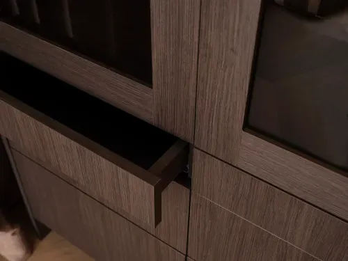 Close-up of a partially open drawer in a dark wood cabinet.