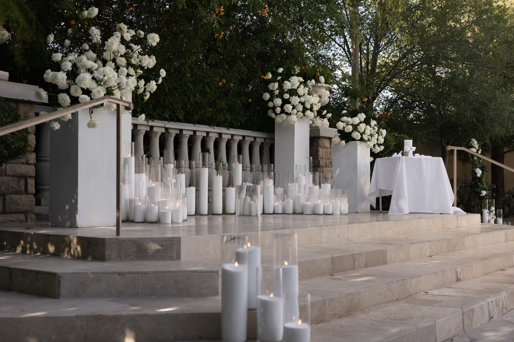 display of candles and flowers on stage with white marble steps
