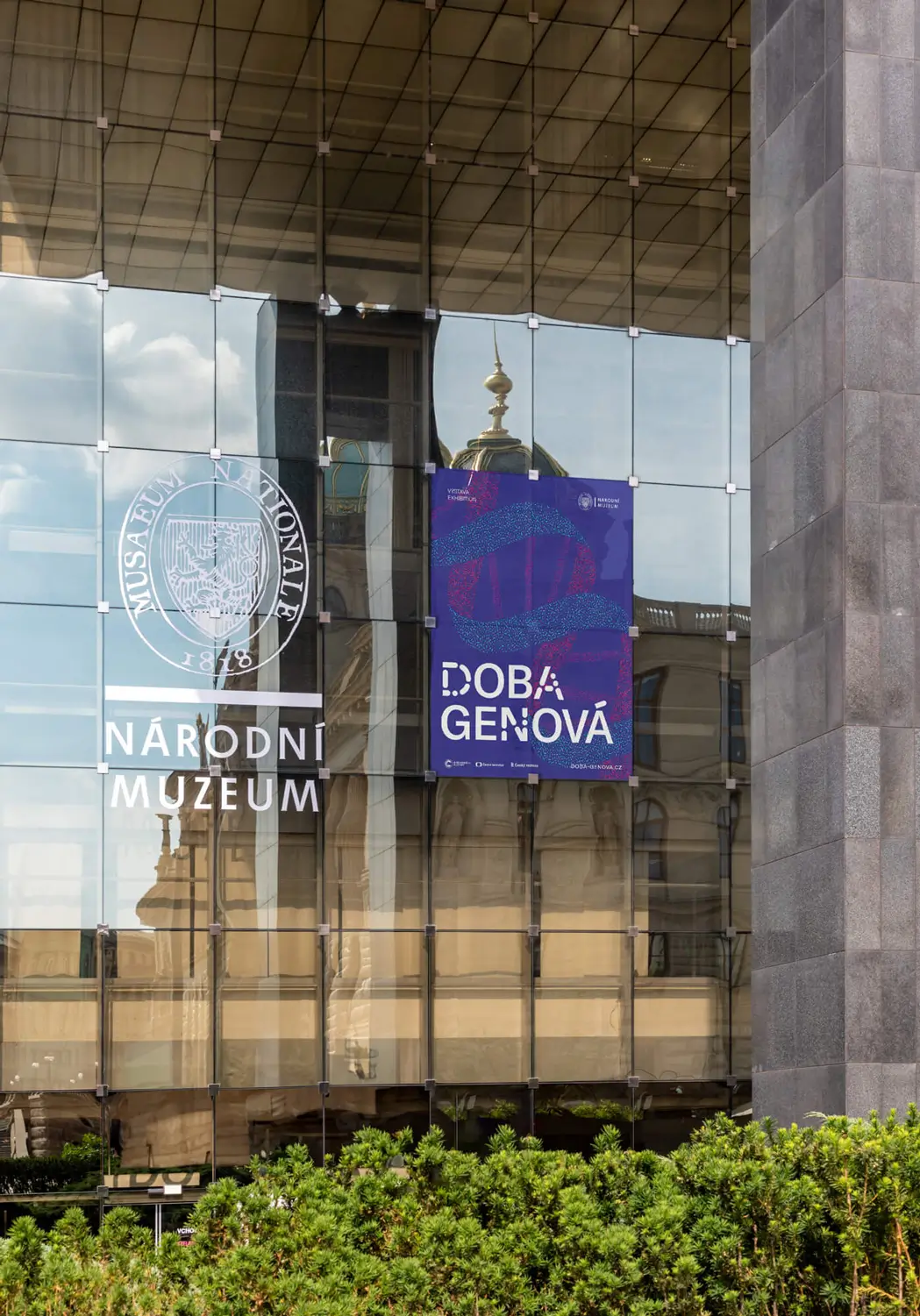 ází kolem velkoformátového panelu výstavy Doba genová s grafy a ilustracemi znázorňujícími evoluční vývoj zvířat pomocí DNA sekvencí.