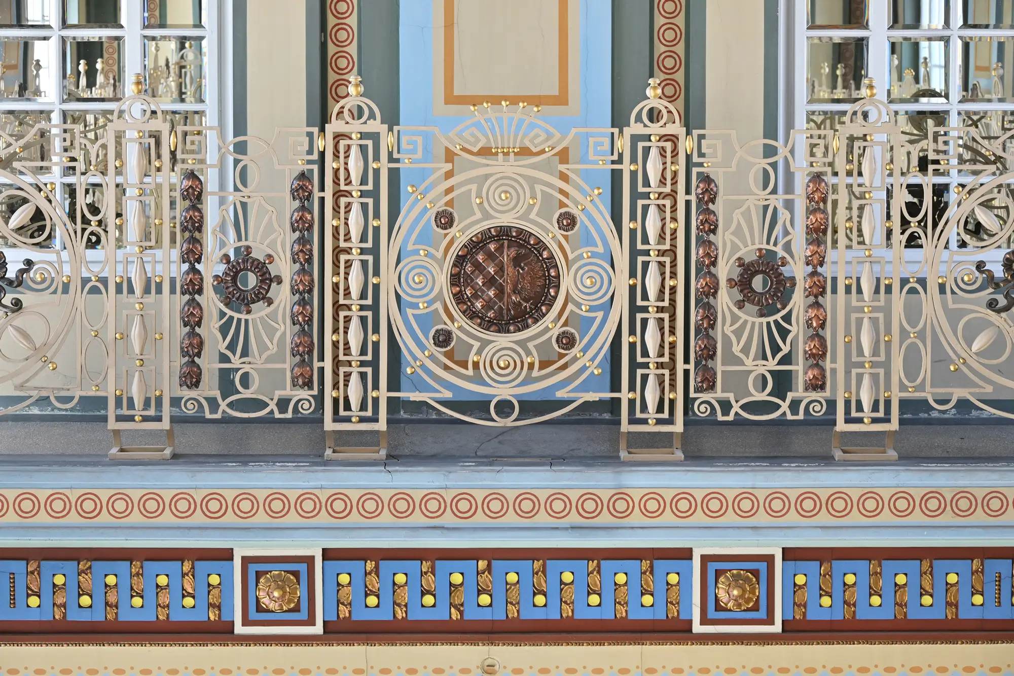 Ornamentální kovové zábradlí s geometrickým motivem v interiéru prostějovské radnice.