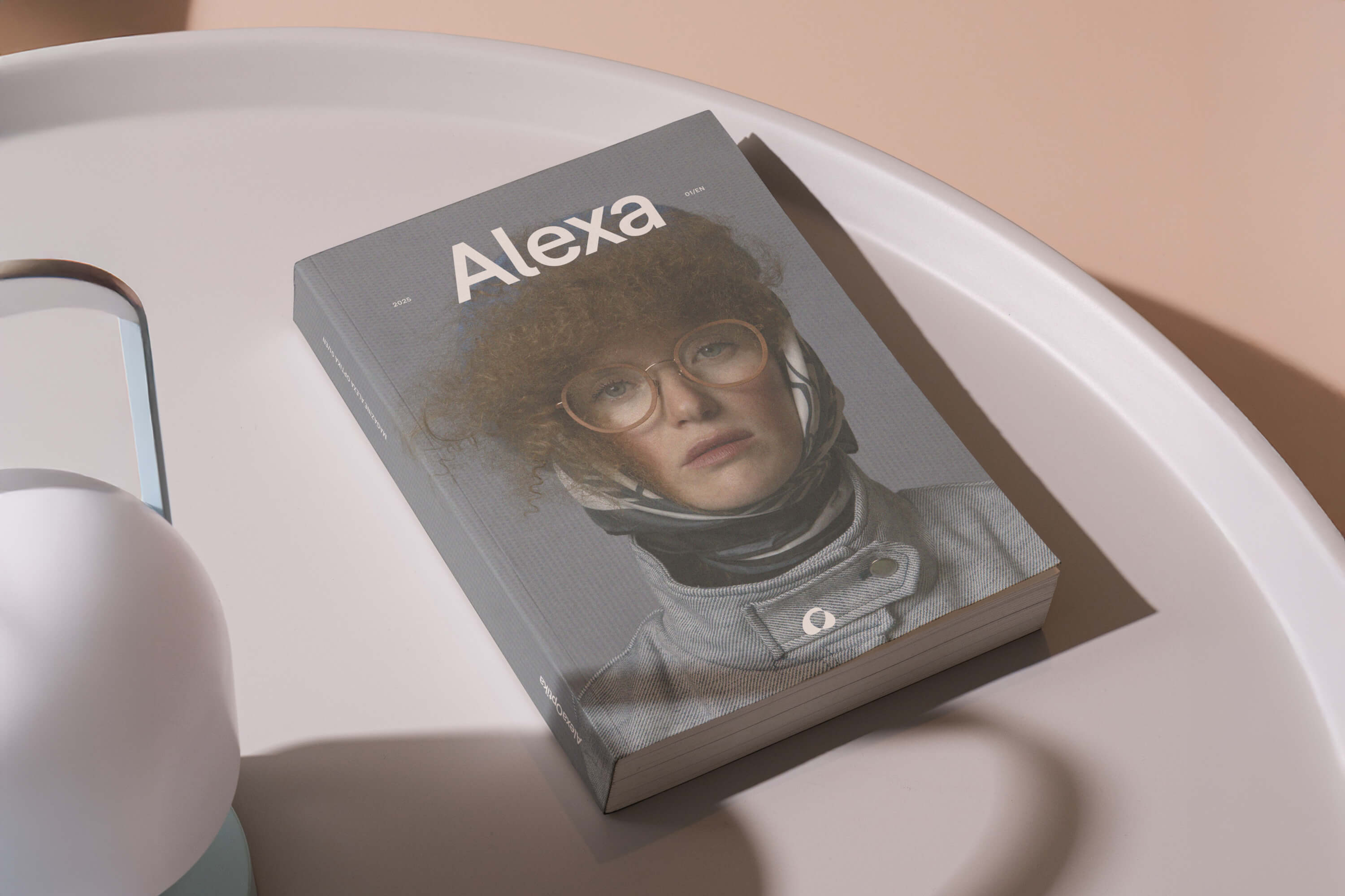 Magazín značky Alexa Optika s obálkou portrétu ženy v brýlích, minimalistické zpracování a jemné světlo.