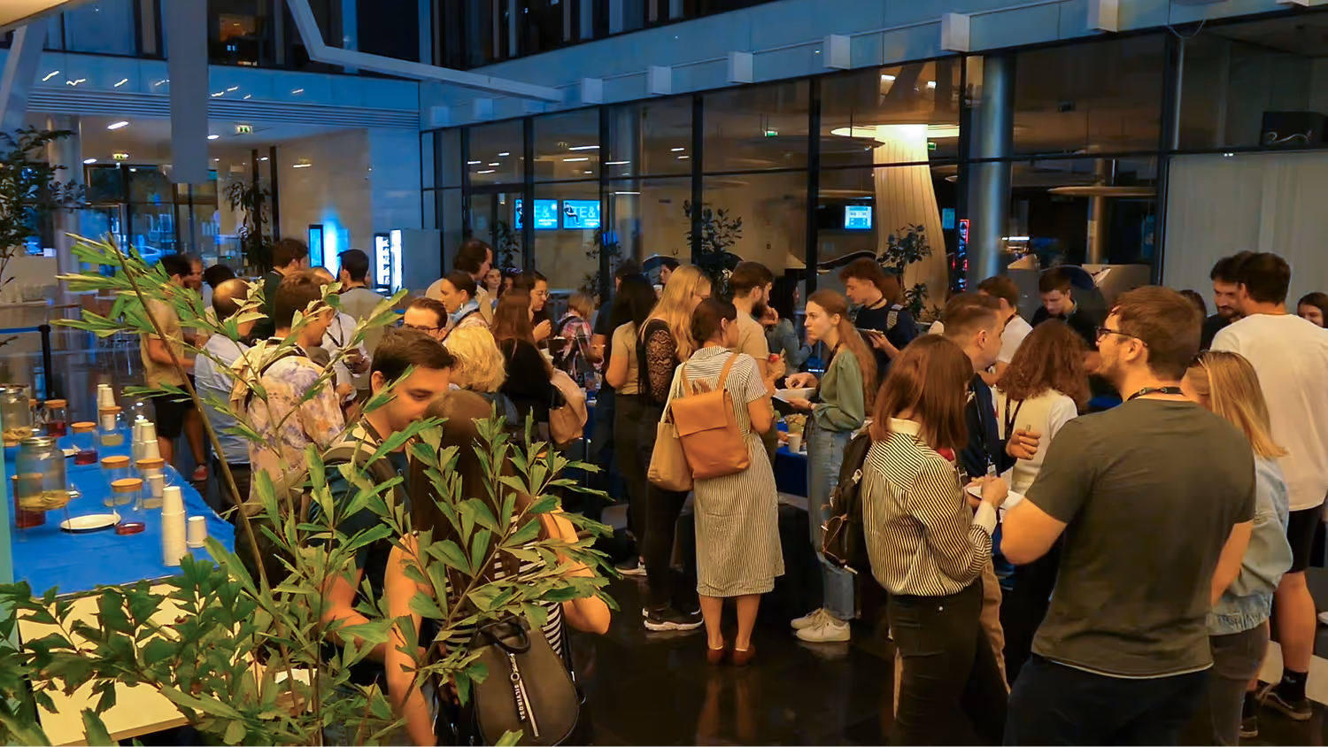 Sok fiatal ember beszélget egy belső térben, szórakoztató vagy szakmai eseményen.