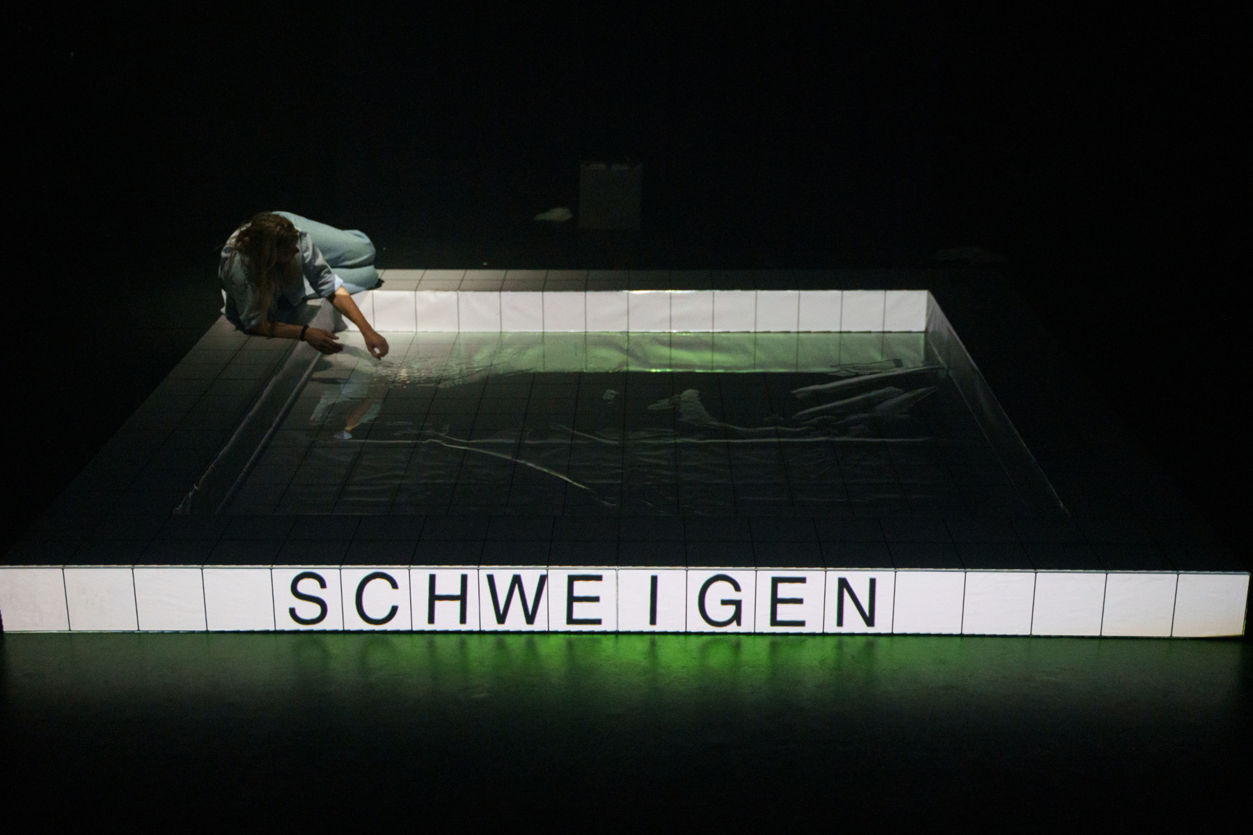 vor Nebel sind als Silhouetten Schwangere in schwarzen Kleidern zu sehen. Sie tragen je einen Eimer.
