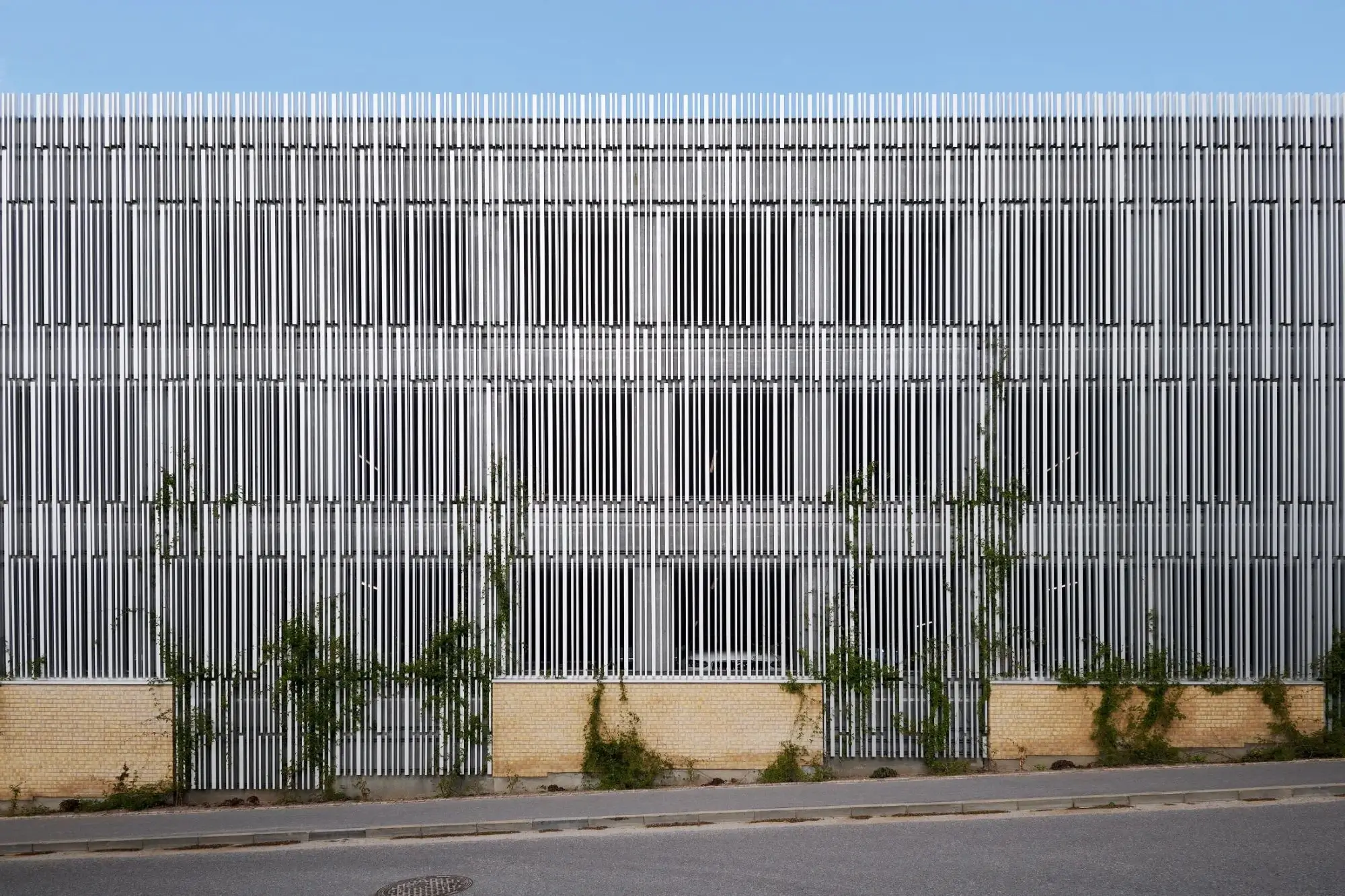 Parkbyen P-hus med facade af lodrette hvide aluminiumslameller i Napsu over gul murstenssokkel