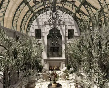 Indoor atrium with arched glass ceiling, chandelier, stone fireplace, and plants flanking a central seating area.