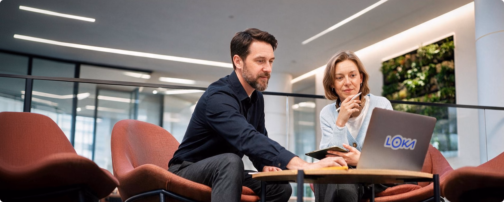 Two Loka colleagues working together on a laptop