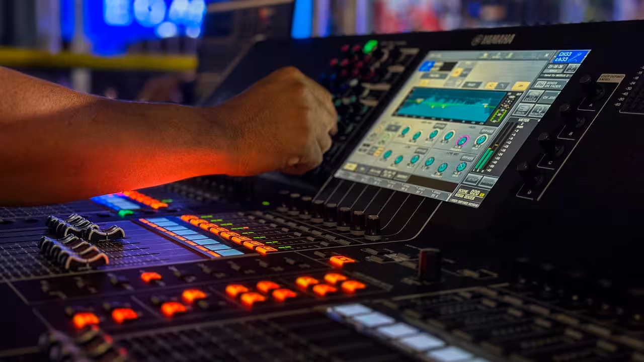 Close-up of an engineer's hand adjusting the touchscreen display of a digital console, demonstrating a complex, visual user interface ideal for a Blazor-based production control panel.