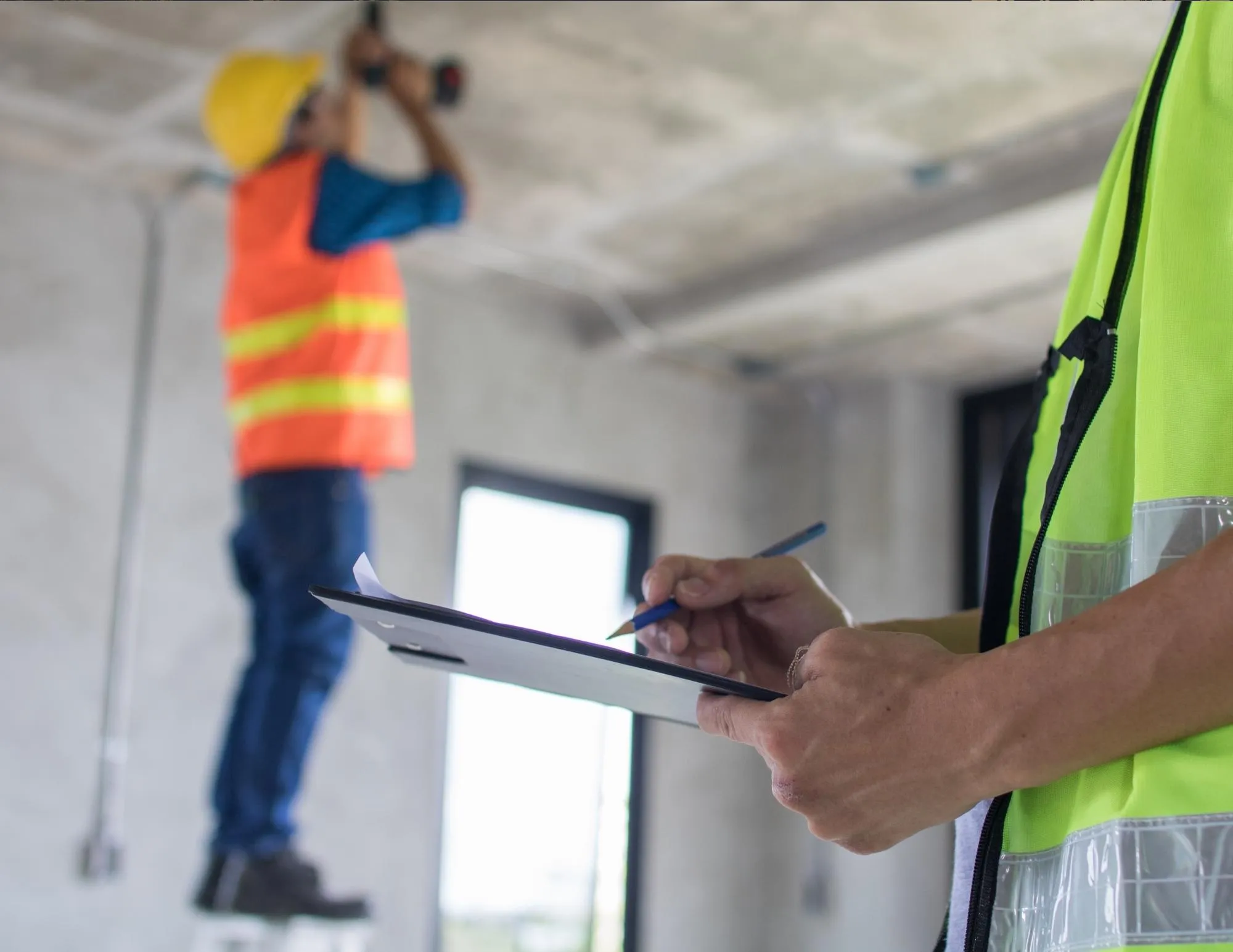 A construction site with a worker checking a clipboard