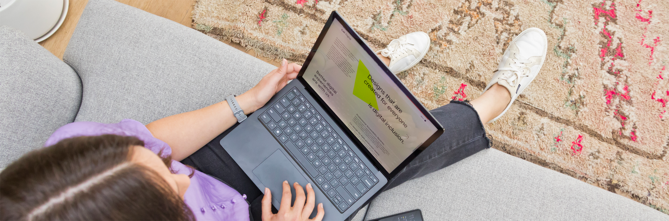 top down view of designer sitting working on laptop